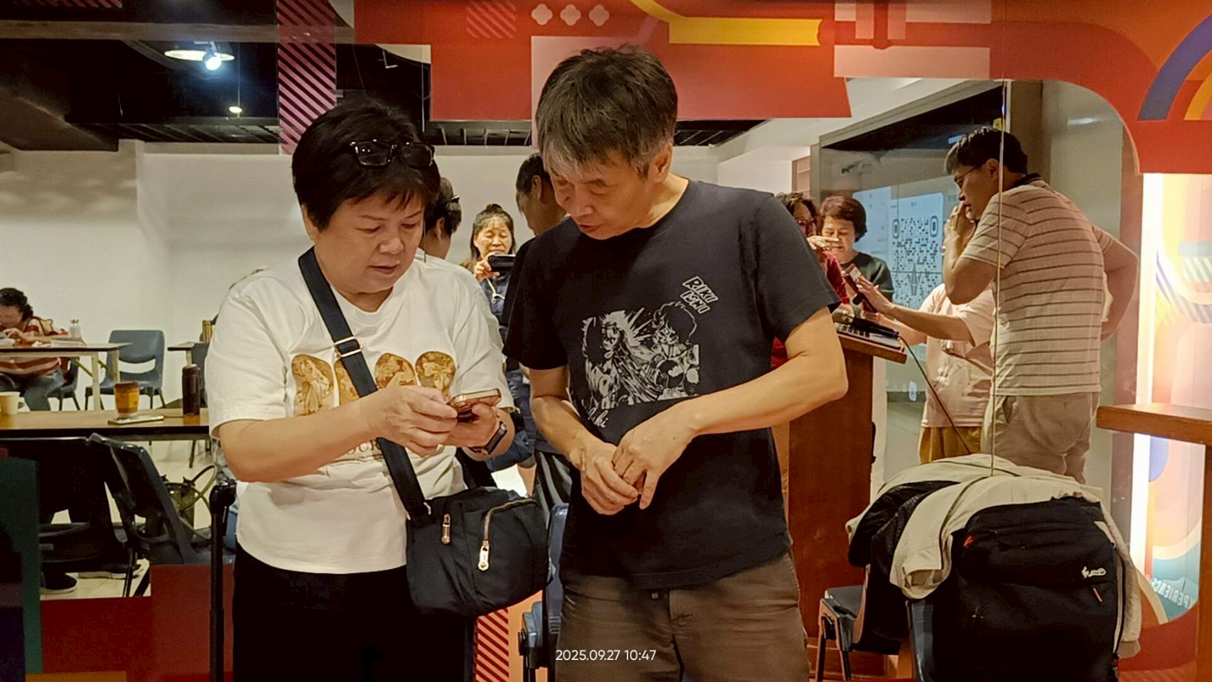 課程活動照片：兩位學員共同查看手機